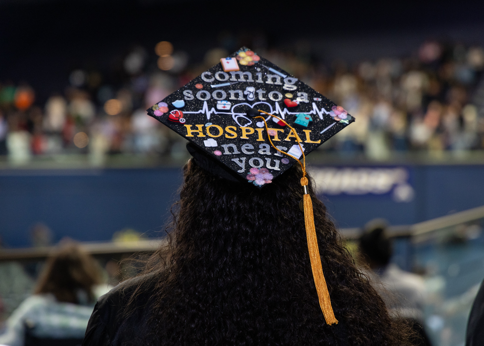 Image of a student wearing a vibrantly decorated graduation cap.